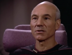 The face says he wants to see how people die in different ways, and says he's going to kill a third or maybe half of the crew. Picard says screw it, let's blow up the ship