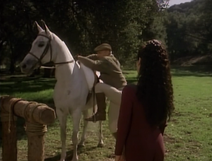 Deanna watches Picard climb on a horse