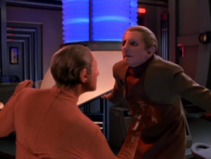 The bad Changeling knocks everyone over and sticks his hand into Odo