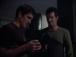 Tuvok follows the guy and sees him meet up with another guy and then they look in a box and smile!
